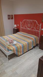 ein Schlafzimmer mit einem Bett mit einer gestreiften Decke und 2 Handtüchern in der Unterkunft La Sanguigna B&B e Locanda in Castelnuovo della Misericordia