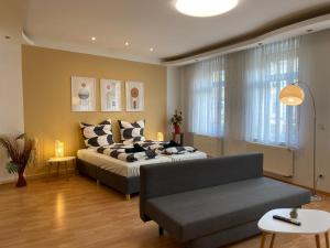 uma sala de estar com uma cama e um sofá em Modern & cozy Rooms Leipzig-Gohlis em Leipzig