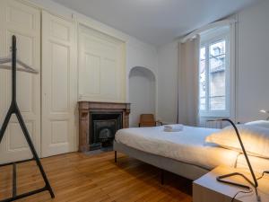 a bedroom with a bed and a fireplace at Le cocon urbain T3, 6 personnes, avec parking proche TRAM ET METRO in Villeurbanne