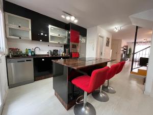 拉古納的住宿－Casa La Laguna，厨房配有柜台和红色吧台凳