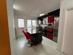 a kitchen with red cabinets and a table with red chairs at Casa La Laguna in Las Lagunas