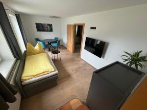 a living room with a couch and a tv at Am Randersberg - Wohnung Nr 4 in Grossgmain