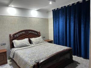 1 dormitorio con 1 cama grande y cortinas azules en دار صوفيا en Fez