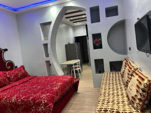 1 dormitorio con 1 cama, TV y mesa en دار صوفيا en Fez