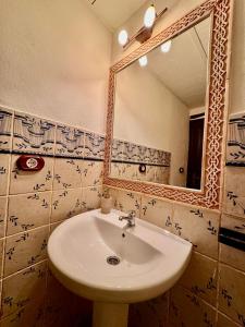 een badkamer met een wastafel en een spiegel bij Apartamento RÚSTICO ÁRABE en el CORAZÓN de Córdoba in Córdoba