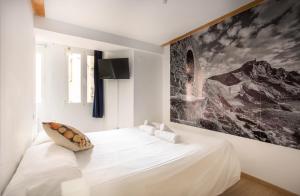 a white bedroom with a large painting on the wall at Apartamentos Bermeo, Museoa in Bermeo