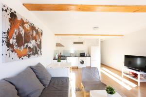 a living room with a couch and a kitchen at Apartamentos Bermeo, Museoa in Bermeo