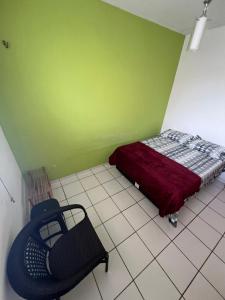 a small bedroom with a bed and a chair at Quarto acolhedor em apto com ótima localização. in São Luís