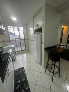 a kitchen with a black counter and a refrigerator at APTO no Centro, COMPLETO, UNIPAR e SHOPPING JL in Cascavel