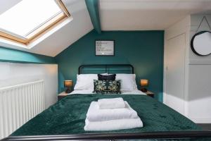 a bedroom with a bed with green walls and a window at Town centre & all the comforts! in Guisborough