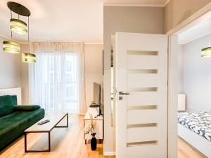 a living room with a green couch and a bed at Wygodne Mieszkania Nova Mikołowska 135 in Katowice