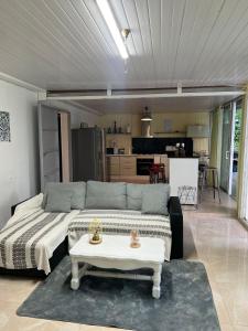 uma sala de estar com um sofá e uma mesa em Villa BEAUCI-TURLET em Goyave