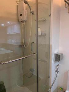 a shower with a glass door in a bathroom at JAMAHSA CONDO STAYCATION TREES RESIDENCES NEAR SM FAIRVIEW in Manila