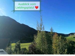 einen Blick auf einen Berg mit einem Schild, das austiologistische Wombleipzig liest in der Unterkunft Ferienwohnung Lieblingsplatzl in Wenns