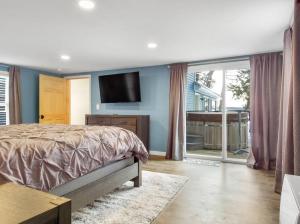 1 dormitorio con 1 cama y TV de pantalla plana en Lakefront Trifecta with Hot Tub & Free Massages, en Augusta