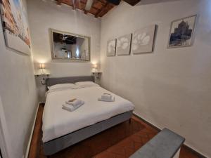 1 dormitorio con 1 cama con sábanas blancas y espejo en I'Biancone, en Florencia