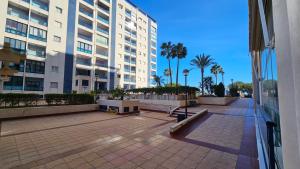 a courtyard in a building with palm trees and buildings at TERRAMAR sweet home in Villajoyosa