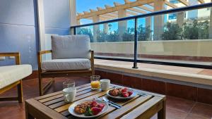 a table with two plates of food on a balcony at TERRAMAR sweet home in Villajoyosa