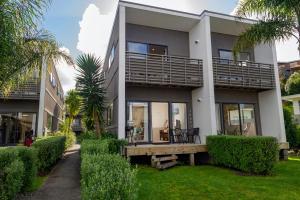 a large house with a porch and balcony at Aqua Soleil Villas in Whitianga