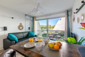 - un salon avec une table et des fruits dans l'établissement L'Éden des Vacances * clim * Terrasse * wifi *Port, à La Grande Motte