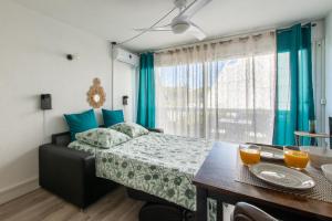 - une chambre avec un lit doté d'oreillers bleus et d'une table dans l'établissement L'Éden des Vacances * clim * Terrasse * wifi *Port, à La Grande Motte 32 autres photos