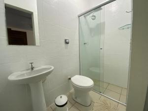 uma casa de banho com um WC, um lavatório e um chuveiro em Pousada Rubbi Violeta em Alto Paraíso de Goiás