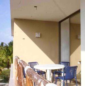 a table and chairs on a balcony with a table at Departamento mar y arena in Chicxulub