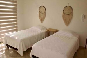 um quarto com duas camas e dois espelhos na parede em Departamento mar y arena em Chicxulub