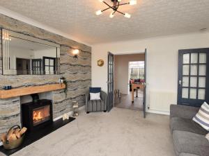 a living room with a stone wall with a fireplace at 2 Bed in Moelfre 75013 in Moelfre