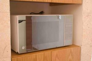a microwave sitting on top of a wooden cabinet at Departamento mar y arena in Chicxulub