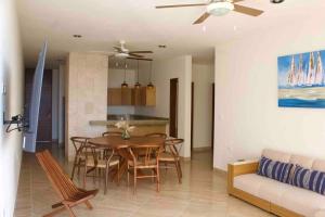 a dining room and living room with a table and chairs at Departamento mar y arena in Chicxulub