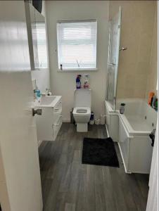 a bathroom with a toilet and a sink and a tub at Macs Belfast Single bedroom in Belfast