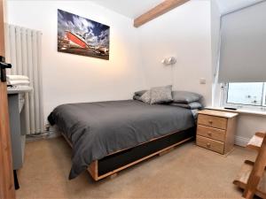 a bedroom with a bed and a desk and a window at 3 Bed in Ilfracombe 66239 in Ilfracombe