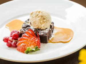 een witte plaat met een dessert met ijs en aardbeien bij Tigh Na Mara Hotel in Sandhead