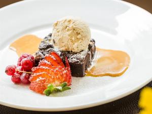 a white plate with a dessert with ice cream and strawberries at Tigh Na Mara Hotel in Sandhead