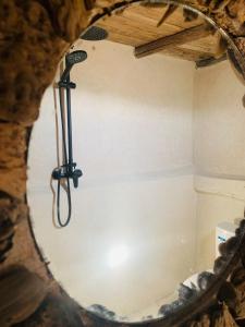 eine Dusche in einer Höhle mit Spiegel in der Unterkunft Momo's beach house in Aghnajane