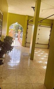 um corredor vazio com duas portas de garagem e uma planta em The Manor Deluxe Suite em Ocho Rios