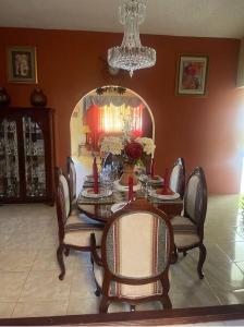 uma sala de jantar com uma mesa e cadeiras e um lustre em The Manor Deluxe Suite em Ocho Rios