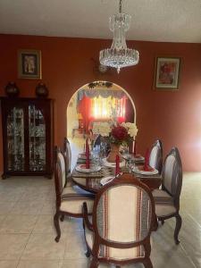 uma sala de jantar com uma mesa, cadeiras e um espelho em The Manor Deluxe Suite em Ocho Rios