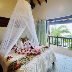 ein Schlafzimmer mit einem weißen Bett mit Baldachin in der Unterkunft Tanna Evergreen Resort & Tours in Insel Tanna