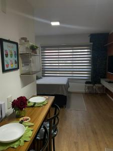 um quarto com uma cama e uma mesa com pratos em Studio novo no Tatuapé ao lado do Metrô Carrão em São Paulo