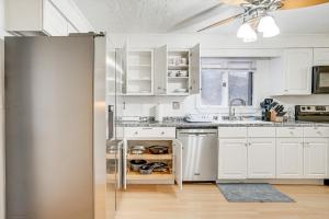 a kitchen with white cabinets and a stainless steel refrigerator at Pet-Friendly Burlington Home 17 Mi to Boston! in Burlington