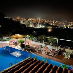 a swimming pool with a view of a city at night at Villa Aladin in Sciacca
