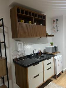 a kitchen with a sink and a microwave at Studio novo no Tatuapé ao lado do Metrô Carrão in Sao Paulo