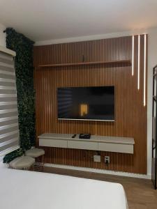 a room with a tv on a wooden wall at Studio novo no Tatuapé ao lado do Metrô Carrão in São Paulo +24 photos