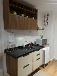 a kitchen with a sink and a microwave at Studio novo no Tatuapé ao lado do Metrô Carrão in São Paulo