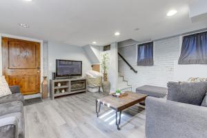 ein Wohnzimmer mit einem Sofa und einem TV in der Unterkunft Cozy Denver Studio with Patio - 1 Mi to Coors Field! in Denver