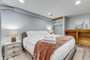 a bedroom with a large white bed and a desk at Cozy Denver Studio with Patio - 1 Mi to Coors Field! in Denver