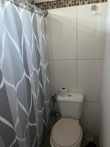 uma casa de banho com um WC e uma cortina de chuveiro em María Chusena alojamiento 2 em Fray Bentos