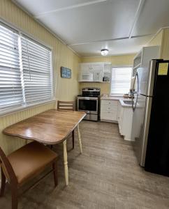 uma cozinha com uma mesa de madeira e um frigorífico em Seashell Village Resort near the beach with kitchens em Port Aransas